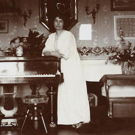 Portrait photographique de Marguerite Burnat-Provins appuyée contre un piano, Lausanne, mai 1908, sans auteur (Fonds Marguerite Burnat-Provins, CLSR)